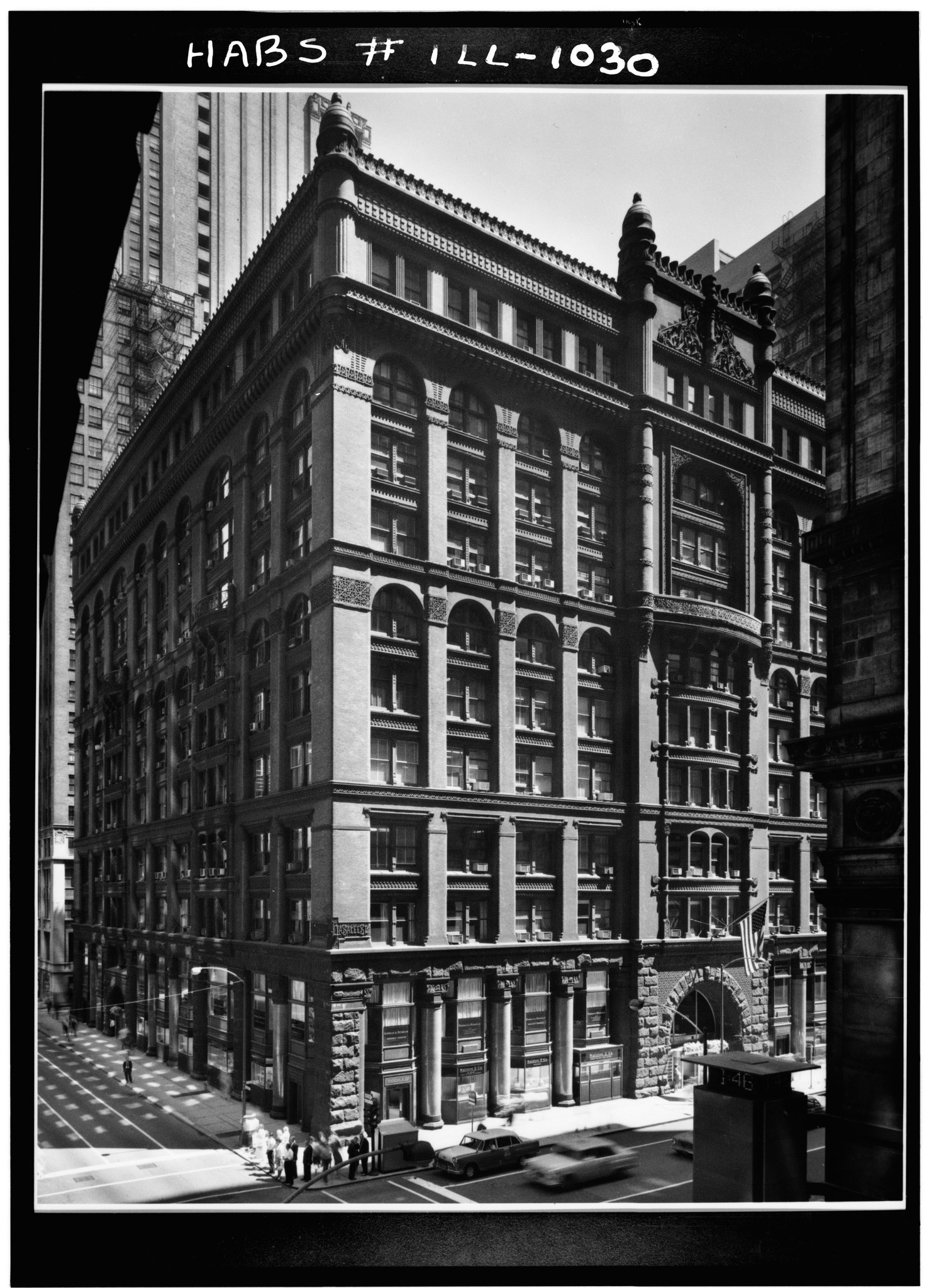 An archival photograph of the Rookery building on a busy Chicago street in 1963.